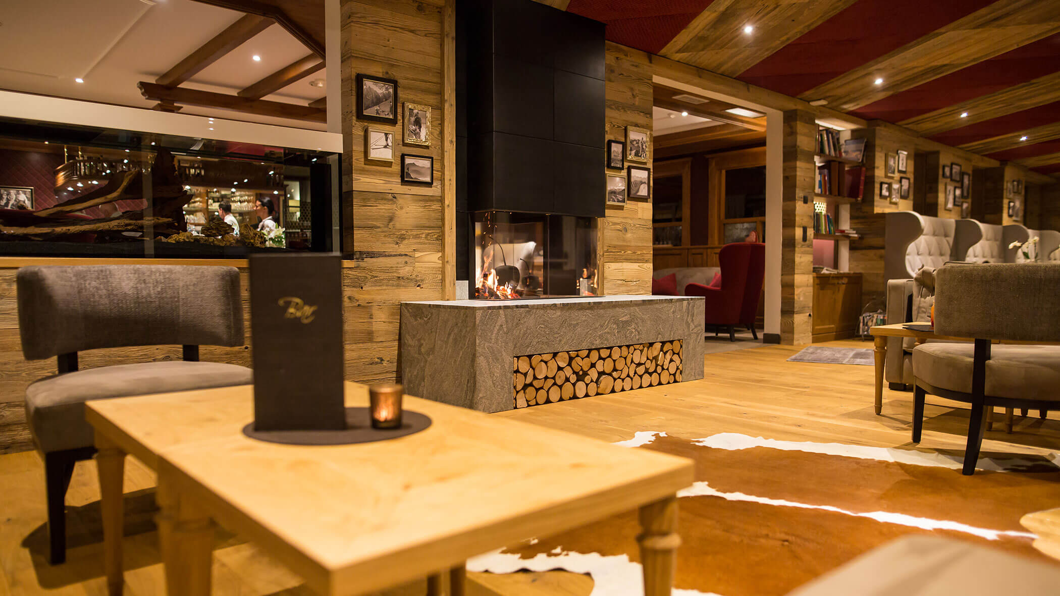 Gemütliche Lounge mit Holzdekor, Kamin, modernen Möbeln und warmer Beleuchtung, die eine entspannte Atmosphäre schafft. - Hotel Magdalenahof